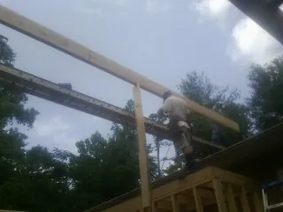 Carpenter setting a ridge beam over a new addition frame — Ice Dam Removal by Roofing Brothers in Capon Bridge