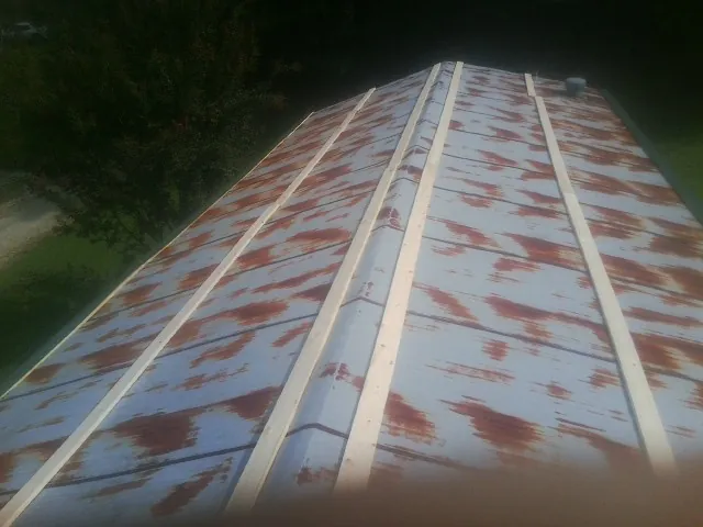 Rusted metal roof panels with new wood purlins before replacement — Storm Damage Roof Repair in Capon Bridge by Roofing Brothers